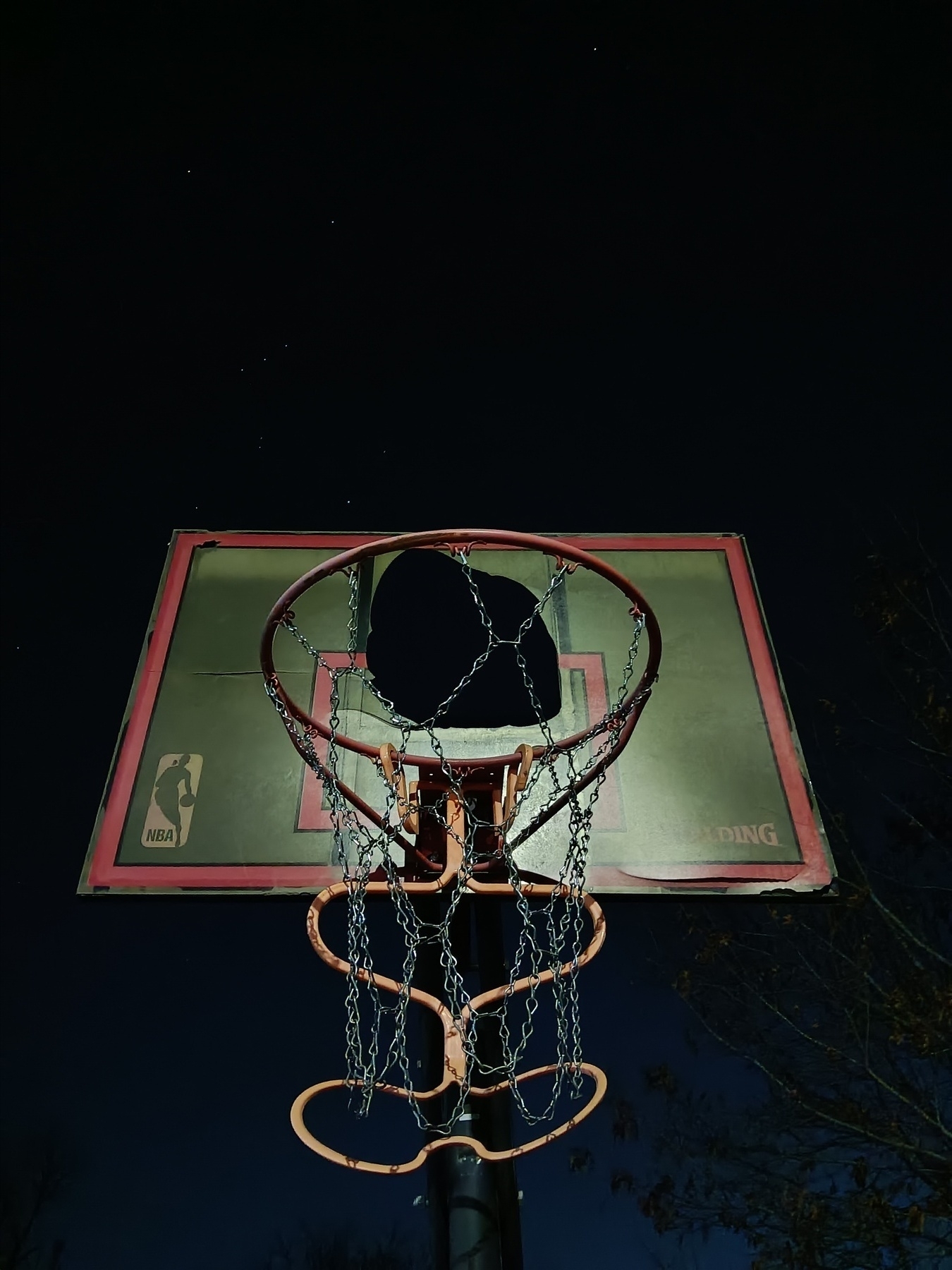 Broken backboard against the night sky.